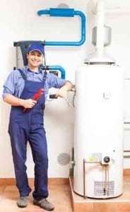 A smiling plumber standing next to a water heater