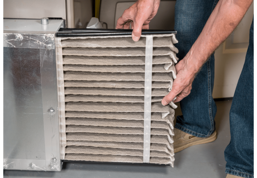 Technician removing dirty furnace air filter