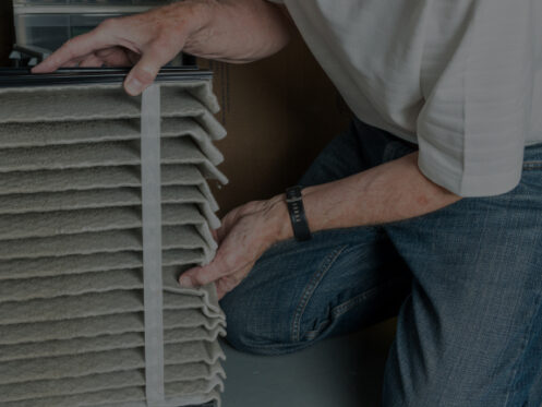 Technician replacing air filter from furnace