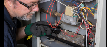 Technician repairing furnace unit