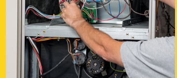 Technician repairing furnace unit