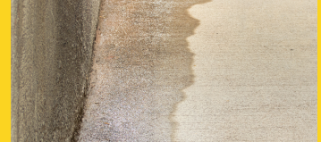 a concrete wall and floor shows water leakage on the ground along the edge where the floor meets the wall